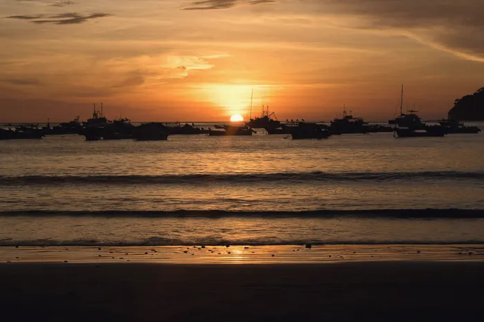 Sunset over San Juan del Sur bay with anchored boats